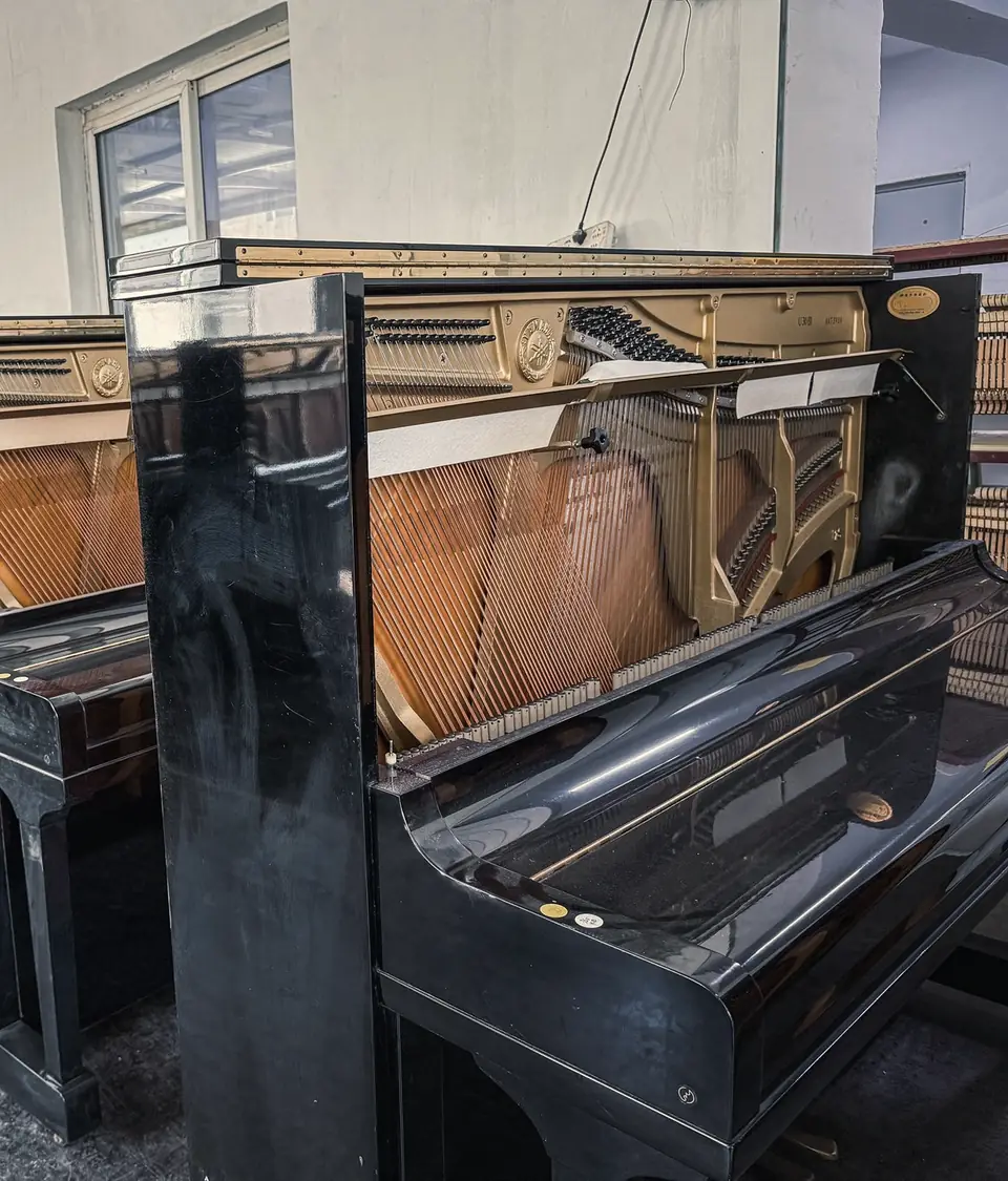 Rows of rebuilt upright pianos in the warehouse