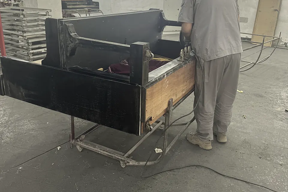 Technician working on a piano case in the workshop