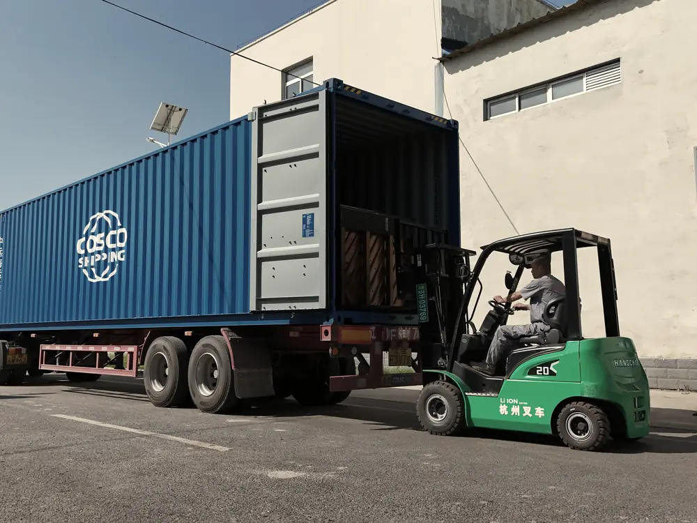 Forklift loading pianos into a shipping container
