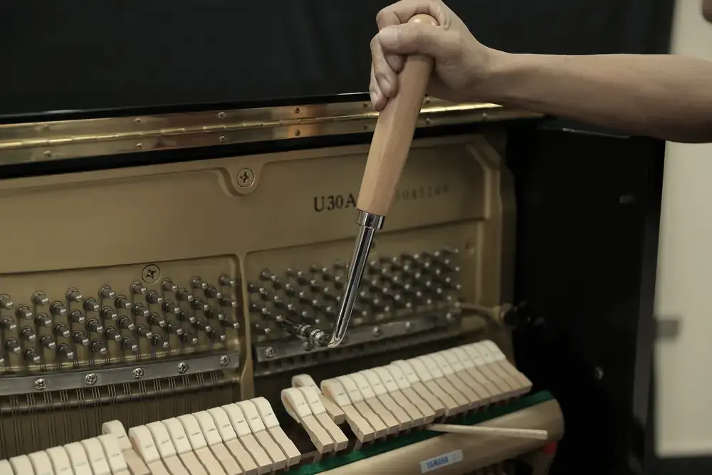 Technician voicing piano hammers